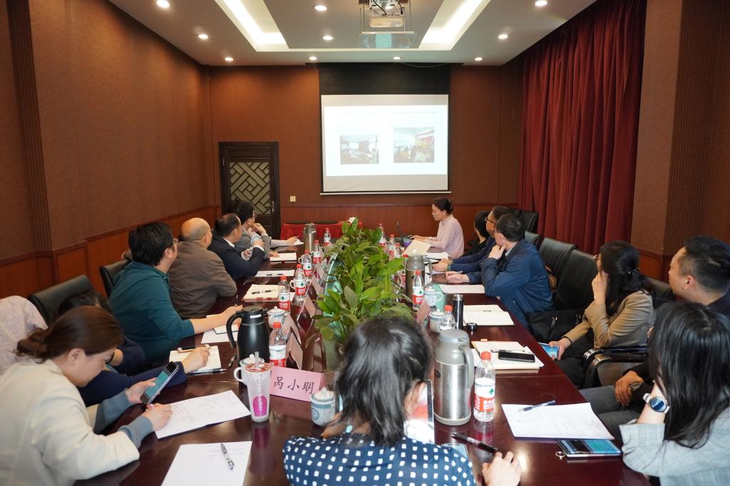 A group of people sitting at a table in a conference roomDescription automatically generated with low confidence